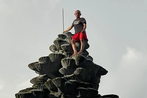 1 người nghi bị tâm thần leo lên tượng đài trước chợ Đà Lạt