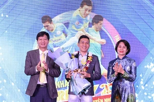 Nguyễn Nhớ chân chất nhận danh hiệu Fair Play 2020 trong sự chúc mừng của ông Lê Khắc Hiệp, Phó Chủ tịch tập đoàn Vingroup (trái) và bà Lê Thị Hoàng Yến, Phó Tổng cục trưởng Tổng cục TDTT.