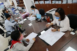 Cán bộ khu vực III TP Thủ Đức giải quyết thủ tục hành chính cho người dân. Ảnh: HOÀNG GIANG