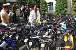 Công an làm việc với nhóm đua xe (ảnh nhỏ) và tang vật đua xe trái phép trên quốc lộ 1 vào rạng sáng 11-4 bị bắt giữ.