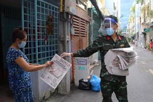Bộ đội Sư đoàn 9 (Quân đoàn 4) phát báo Pháp Luật TP.HCM cho người dân cư xá Đô Thành (phường 4, quận 3, TP.HCM) vào chiều 3-9.