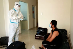 Nhân viên y tế BV dã chiến số 12 giải thích với F0 nhập cảnh việc sử dụng ghế xếp.