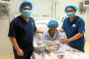 Bệnh nhân Lê Thị Lệ Thủy, ca ECMO cuối cùng của BV dã chiến ba tầng số 14, bên các y bác sĩ điều trị cho mình. 