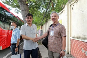 Ông Lê Trường Sơn (trái) động viên, dặn dò cán bộ, giảng viên trước giờ khởi hành đi Bình Thuận làm công tác kiểm tra thi.