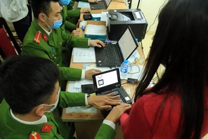 Lực lượng công an làm thủ tục cấp CCCD gắn chip cho người dân.