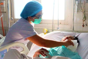 Chị Nguyễn Thị Kiều Mỹ, điều dưỡng CKI Khoa nhiễm Việt - Anh (BV Bệnh nhiệt đới), đang chăm sóc bệnh nhân.