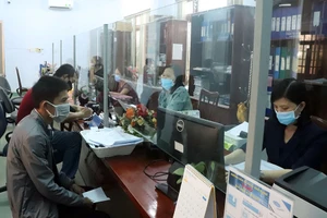 Người lao động làm thủ tục nhận hỗ trợ từ cơ quan BHXH.