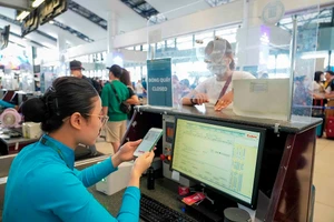 Nhân viên hàng không kiểm tra giấy tờ của hành khách đi máy bay qua ứng dụng VNeID.