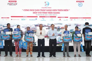 Ông Trương Hòa Bình, nguyên Ủy viên Bộ Chính trị, nguyên Phó Thủ tướng thường trực Chính phủ, cùng lãnh đạo tỉnh Tiền Giang trao quà cho ngư dân.