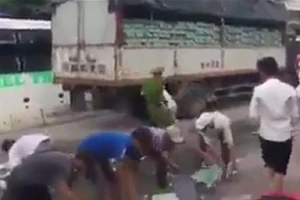 Xe chở bia bị đổ, CSGT và người dân cùng nhặt giúp