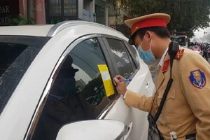 CSGT thực hiện việc dán thông báo xử phạt lên kính xe ô tô