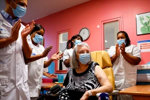 Các nhân viên bệnh viện Rene-Muret, ngoại ô thủ đô Paris vỗ tay chúc mừng người Pháp đầu tiên được tiêm vaccine ngừa COVID-19 hôm 27-12-2020. Ảnh: REUTERS