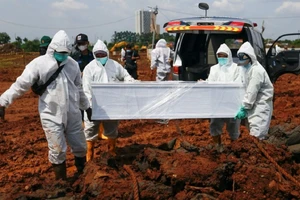 Lực lượng y tế đặc biệt chôn cất một bệnh nhân qua đời vì COVID-19 ở Jakarta (Indonesia). Ảnh: REUTERS