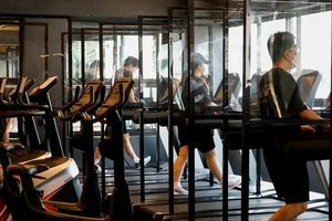Các phòng gym ở Hàn Quốc lắp tấm chắn giữa các máy chạy bộ để giảm nguy cơ lây COVID-19. Ảnh: REUTERS