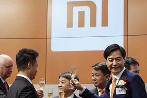 Ông Lôi Quân (bên phải, cài hoa) - nhà sáng lập, đồng thời là tổng giám đốc điều hành công ty Xiaomi. Ảnh: REUTERS