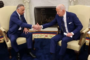 Tổng thống Mỹ Joe Biden (phải) và Thủ tướng Iraq Mustafa al-Kadhimi (trái) bắt tay nhau trong Phòng Bầu dục hôm 26-7. Ảnh: REUTERS