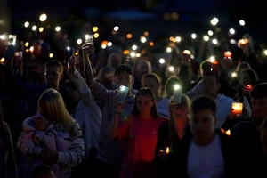 Người dân Plymouth (Anh) hôm 13-8 cầu nguyện cho các nạn nhân vụ xả súng tối 12-8. Ảnh: PA