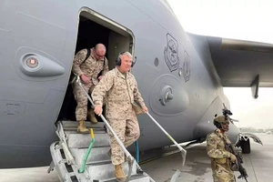 Tướng Frank McKenzie (người đeo bộ đàm) tới sân bay Kabul hôm 17-8, chỉ đạo chiến dịch rút quân và di tản khỏi Afghanistan. Ảnh: REUTERS