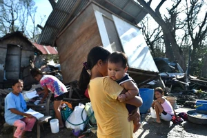 Người sống sót ở bên ngoài TP Carcar thuộc tỉnh Cebu, Philippines ngày 18-12. Ảnh: AFP