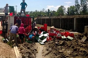 Lật xe chở bia, người dân giúp tài xế gom lại tài sản