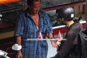 Phải cầm điện thoại để đưa tiền cho người bán nước dừa