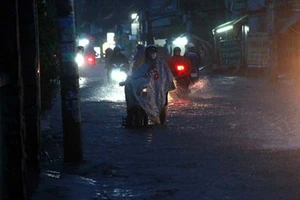 Triều cường ở TP.HCM, người dân giúp nhau đẩy xe qua đoạn ngập