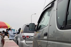Nhiều tài xế điều khiển ô tô vào TP.HCM được kiểm tra y tế tại khu vực cầu Đồng Nai. Ảnh: TỰ SANG 