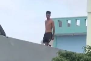 Thanh niên ngáo đá lên mái nhà la hét, ném gạch xuống đường