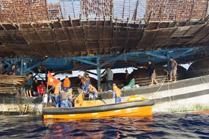 Hình ảnh cảnh sát biển tiếp cận, hỗ trợ ngư dân tàu câu mực bị chìm