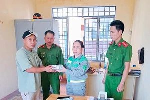 Nữ lao công nhặt được gần 100 triệu liền mang đến công an nhờ tìm người đánh rơi. Ảnh: HP