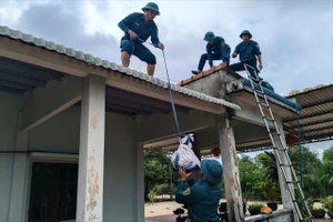 Dân quân giúp dân chằng chống nhà cửa ứng phó bão số 12