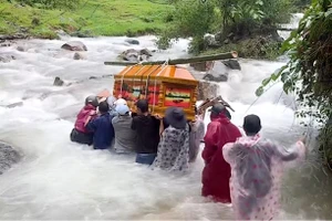 Clip xót xa nhóm người khiêng quan tài băng qua dòng lũ dữ