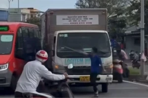 Tài xế xe tải chặn xe, cầm thanh sắt thách thức tài xế xe buýt. Ảnh: TN