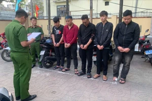 Công an đọc lệnh bắt ba bị can (bên trái). Ảnh: CA