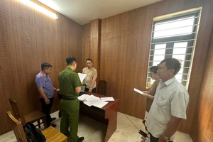 Tống đạt quyết định bắt tạm giam đối với ZHANG JUNHUA. Ảnh: CA