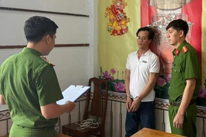 Công an đọc lệnh bắt bị can Huy. Ảnh: CA