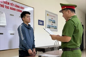 Công an đọc lệnh bắt đối với Huy. Ảnh: CA