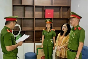 Tống đạt quyết định khởi tố bị can Lê Thị Oanh. Ảnh: Ca