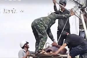 Người dân dựng giàn giáo đưa thi thể trên dây điện xuống đất 