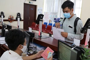 Người dân làm thủ tục đăng ký thường trú. Ảnh: LÊ THOA