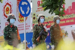 Ba chiến sĩ của Sư đoàn 5 tham gia hỗ trợ kiểm soát tại chốt trên đường Phạm Văn Đồng (quận Thủ Đức, TP.HCM). Ảnh: HOÀNG TRƯỜNG 