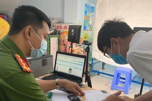 Người dân điền thông tin khi làm thủ tục cấp đổi thẻ CCCD. Ảnh: HỮU ĐĂNG