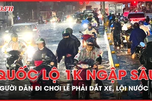 Mưa lớn, nhiều người đi chơi lễ phải dắt xe, lội nước trên quốc lộ 1K