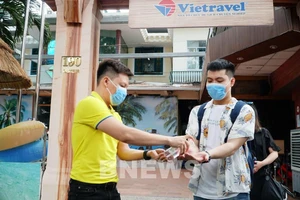 Thực hiện an toàn khử khuẩn tay cho du khách. Ảnh: Hằng Trần/BNEWS/TTXVN