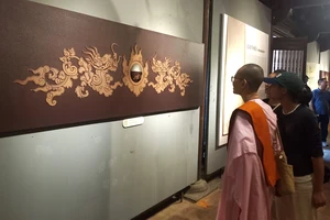 Du khách thích thú chiêm ngưỡng hoạ tiết rồng trên 82 bia Tiến sĩ 