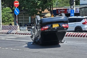 Ô tô tông dải phân cách rồi lật ngửa, người dân phá cửa cứu người