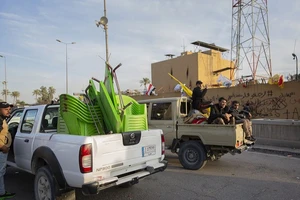 Người biểu tình thu dọn và rời khỏi Đại sứ quán Mỹ ở Baghdad. Ảnh: AP