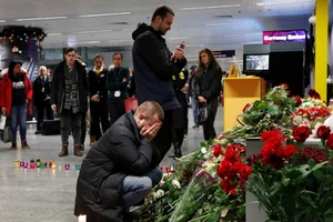 Người dân thương tiếc trước di ảnh những nạn nhân Canada thiệt mạng trong vụ bắn rơi máy bay ngày 8-1 ở TP Toronto (Canada). Ảnh: AFP