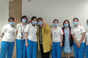 Bà Giang chụp ảnh cùng các y bác sĩ điều trị cho mình tại Trung tâm Phòng chống bệnh truyền nhiễm Singapore. Ảnh: CNA