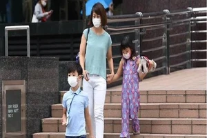 Người dân mang khẩu trang khi đi ra ngoài tại Singapore. Ảnh: CHANNEL NEWS ASIA